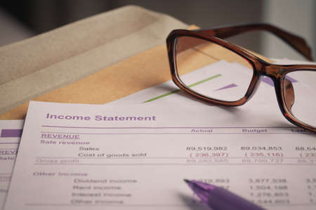 Income statement letter on brown envelope and eyeglass pen  business concept document is mockupの写真素材