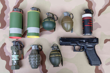 All explosives, weapon army,standard time fuze, hand grenade and gun on camouflage background, top viewの写真素材