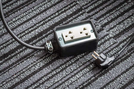 Electrical socket with power plug cable on carpet floor for safety concept