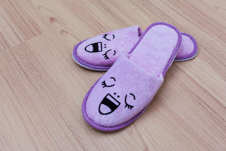 smile slippers and happy, close up view, on wooden floorの写真素材