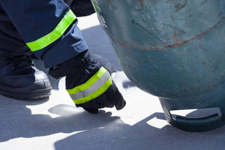 fire trainer, pouring liquid LPG gas into bottle by upside down for conflagration preventive extinguish training, safety conceptの写真素材