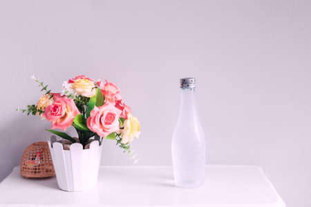 flower and bottle of water, on white tableの写真素材