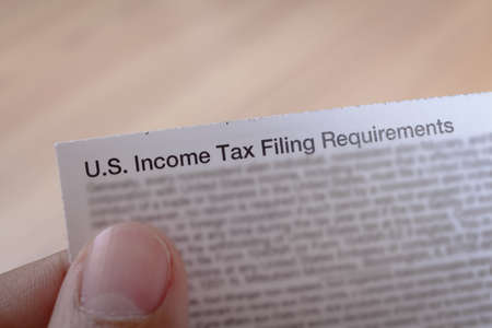 US incoming tax and hand for business concept backgroundの写真素材