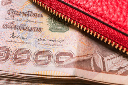 red leather wallet with thai banknote money, close upの写真素材