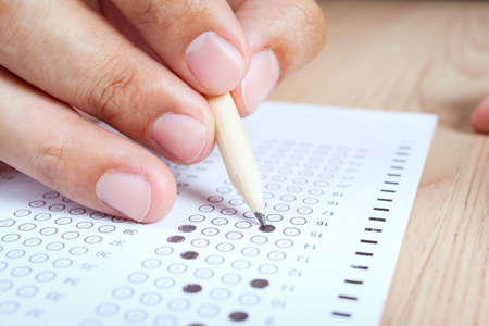 hand fill in Exam carbon paper computer sheet and pencilの写真素材