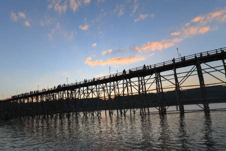 silhouette of Utamanusorn Bridge (Mon Bridge), made from wooden for across the river in Sangkhlaburi District, Kanchanaburi Thailand and blue skyの写真素材