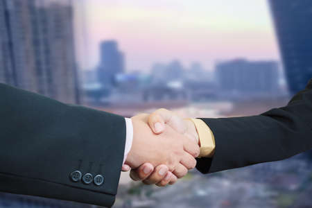 Business handshake with blur background of business buildings area and office, cityscapeの写真素材