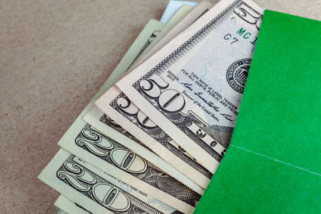 banknotes US, in green envelope on brown paper background, financial conceptの写真素材