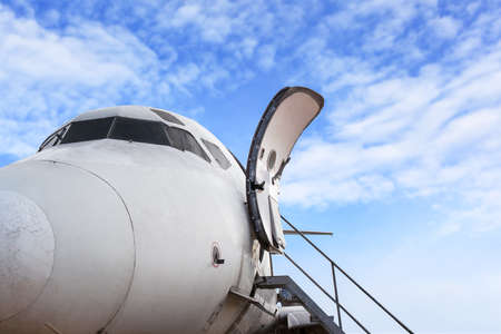 airplane door of private jet and open ladder at the airport on bule sky background, for travel conceptの写真素材