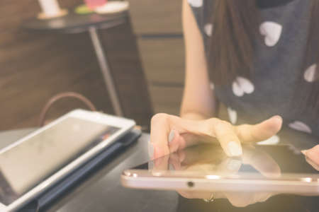 woman hand use mobile phone for internet connection or shopping online and reading at workplace, can use as backgroundの写真素材