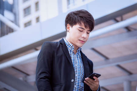 businessman using a cell phone and modern office building backgroundの写真素材