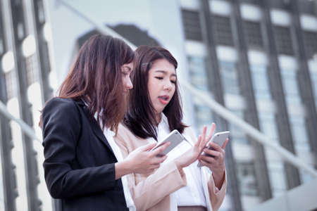 business woman using a cell phone with colleague and discussion topic on business conceptualの写真素材