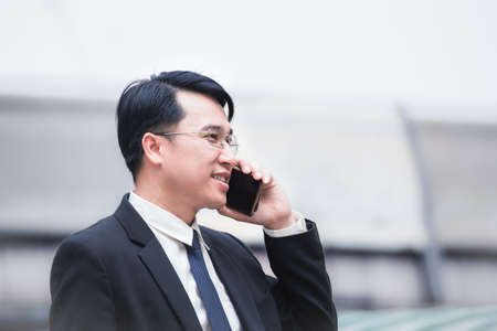 businessman using a cell phone and modern office building backgroundの写真素材