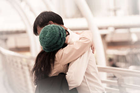 Asian happy woman wearing yarn hat meet and hugging with boyfriend together at the street, wedding theme backgroundの写真素材