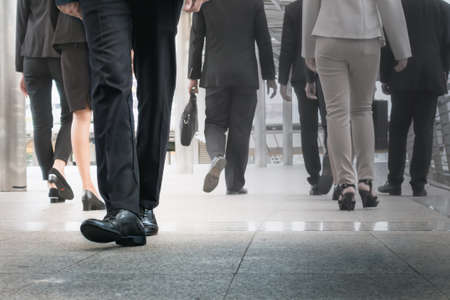 businessman legs walking go forward as outstanding by other legs walking as opposite direction on business streetの写真素材