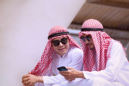Arabian businessman using cell phone with colleauge for presenting business concept backgroundの写真素材