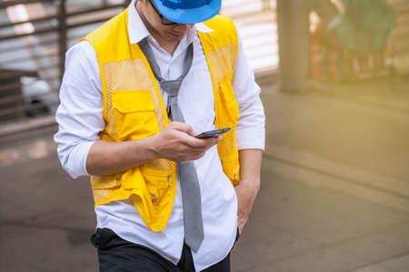 asian businessman engineer standing and use smartphone for chat and sending mailの写真素材