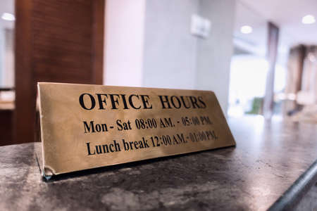 Office Hours gold metal sign on desk for business opening with announcement and give information for customerの写真素材