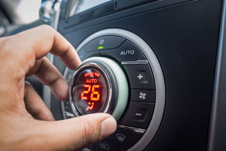 hand adjusting air conditioner button at 26 degree in the vehicle or car for comfortableの写真素材