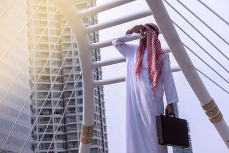 Confident Arabian Businessman standing and looking at city background for vision conceptの写真素材