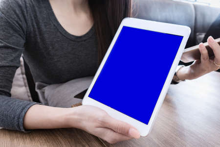 woman hand holding mobile phone tablet with blank screen for advertising text message or promotional...