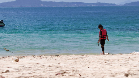 Unidentified tourist walking on the beach.のeditorial素材