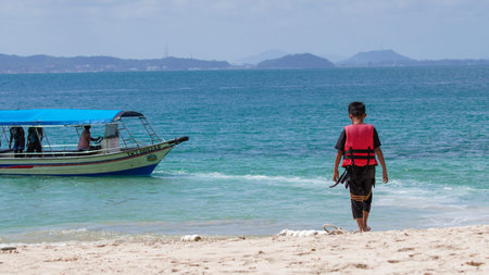 Unidentified man with life jacket walking on the beach in Koh Phangan, Thailandのeditorial素材