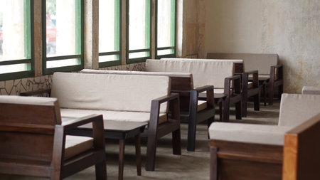 Interior of a coffee shop with tables and chairs in a row