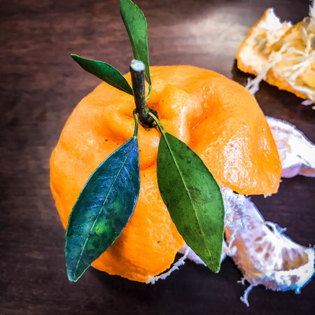 Ripe tangerine with leaves on a wooden background. Toned.の写真素材
