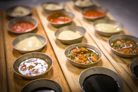 Closeup of various types of sauces in bowls on a wooden tableの写真素材