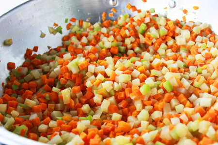Chopped carrots and celery in a stainless steel pot, closeupの写真素材