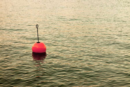 Bouy by the lake - Red bouy on a calm lakeの写真素材