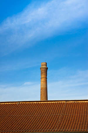 Old brick chimney isolated on sky with copy sapceの写真素材