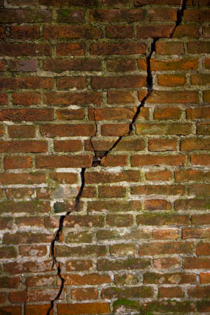 Deep crack in a brick wall - concept imageの写真素材
