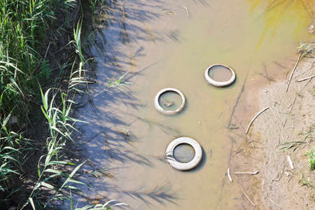Illegal dumping. Car tires illegally abandoned in a ditchの写真素材