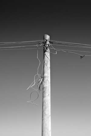 Wooden telephone pole with disconnected cablesの写真素材