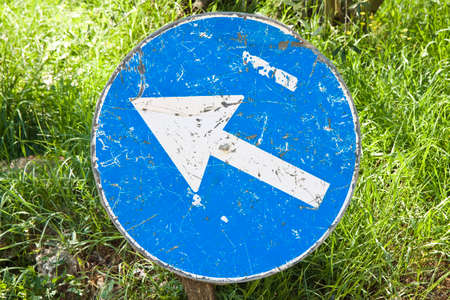 Road sign with blue arrow in the countrysideの写真素材