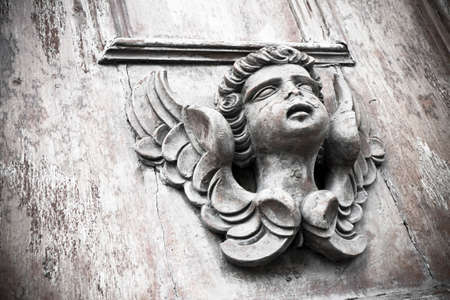 Sculpture of an angel on a wooden doorの写真素材