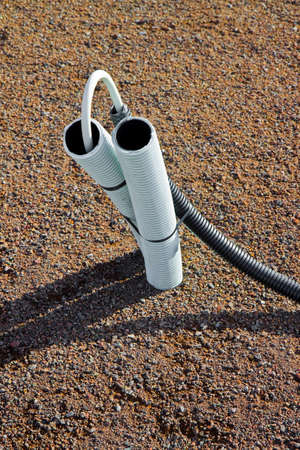 Corrugated pipe with cable coming out from the ground