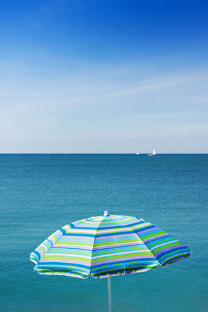 Beach blue umbrella against the seaの写真素材