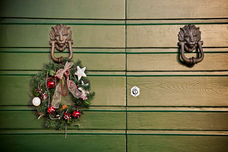 Festive garland Christmas hanging on a old wooden door