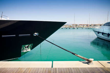 Small creek in a marina (new harbor in Pisa - Tuscany - Italy) with bow of a boat in the foregroundの写真素材