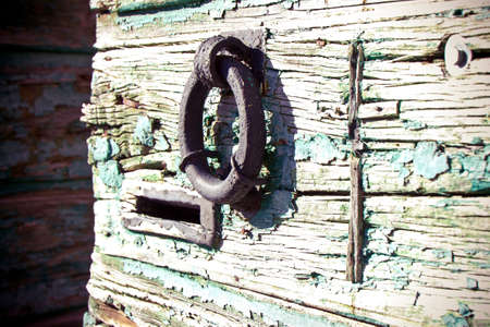 Metal knocker door on a wooden ancient doorの写真素材