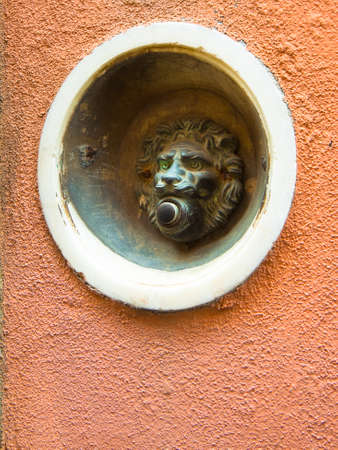Old bell system in shape of lion on colored plaster (Tuscany - Italy) with copy space