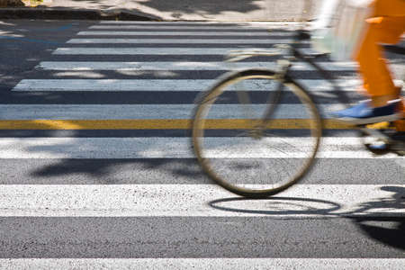 Bicycle riders on pedestrian crossing in motion blur with copy spaceの写真素材