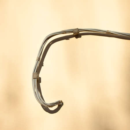 Electrical power cables against a plaster wallの写真素材