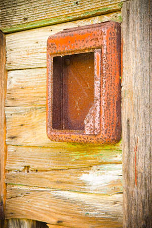 Old red mail box against a wooden door.の写真素材