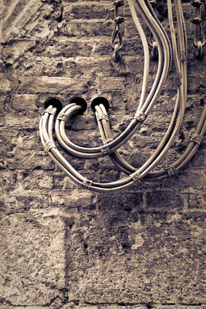 Electrical cables fixed on the wall for the distribution of electricity supply. (Toned image)