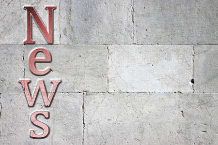 News carved on white stone wall - concept image with copy space on the rightの写真素材