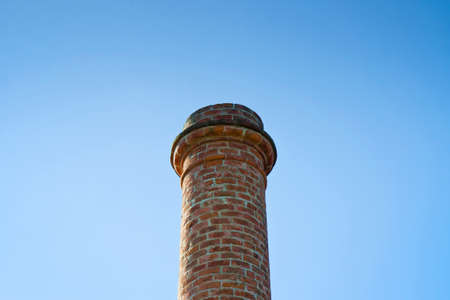 Old brick chimney isolated on sky with copy spaceの写真素材